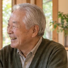 お茶を片手に楽しそうに笑う男性のご利用者さま
