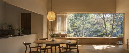 大きな窓から木立を望む、ダイニングのある住まい